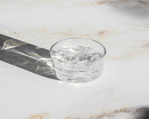 glass of water with ice on a sunny desk
